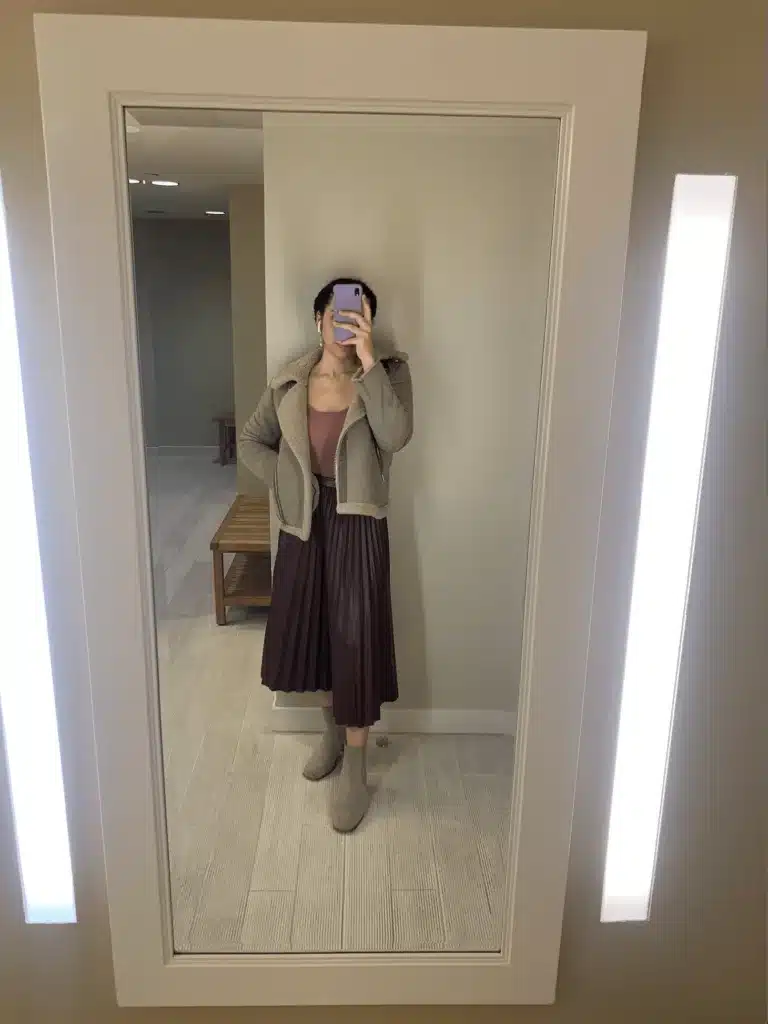 woman in shearling jacket, pink bodysuit and leather skirt