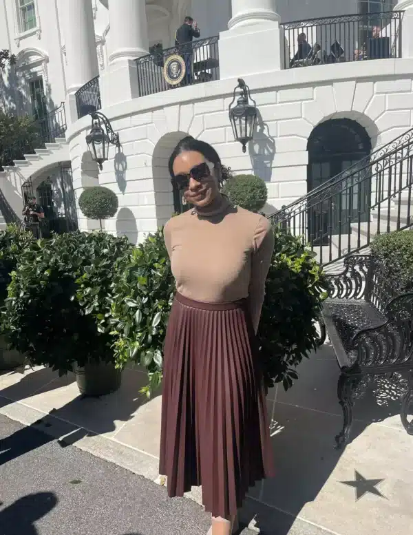 woman in pleated leather skirt and turtleneck