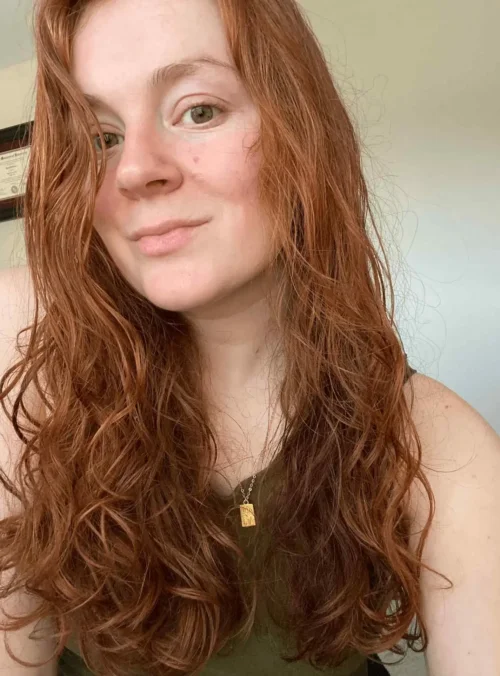 woman wearing a simple pendant necklace and green tank top