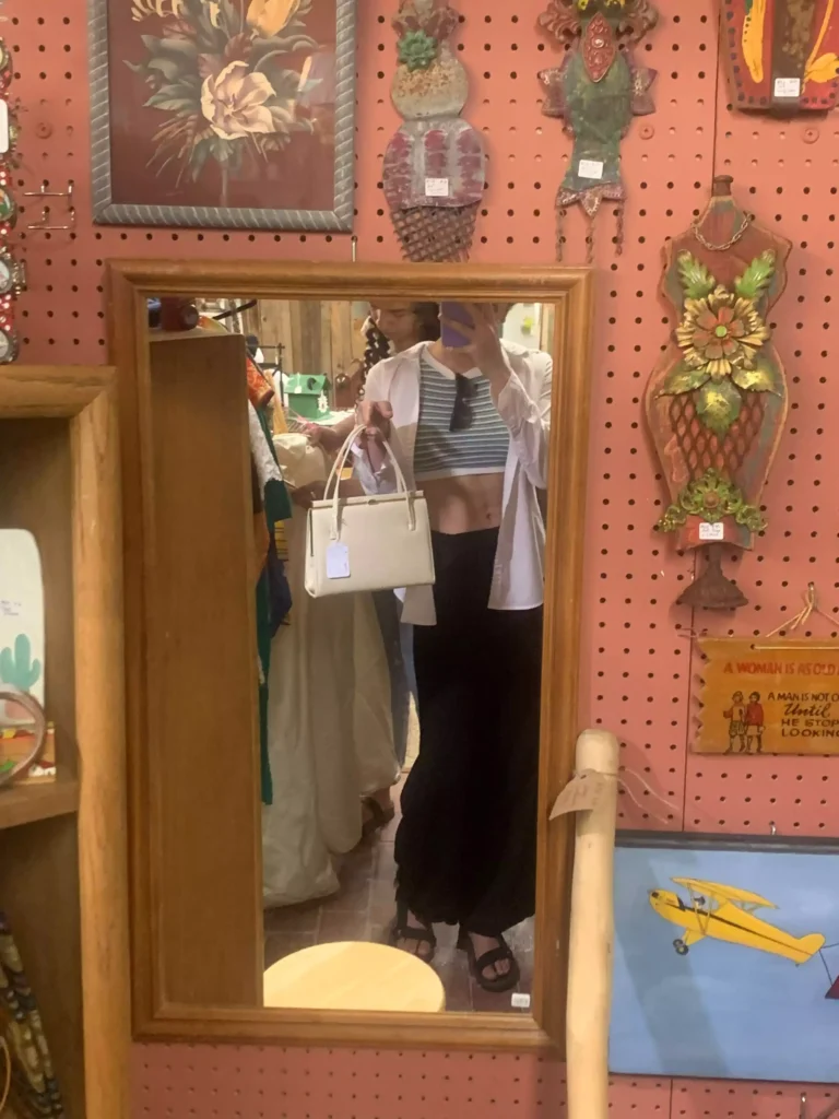 woman thrift shopping for capsule wardrobe