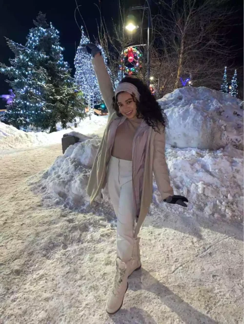 woman wearing gloves and winter coat in snow.