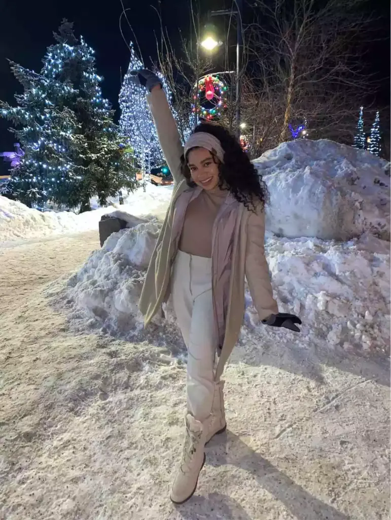 woman wearing gloves and winter coat in snow.