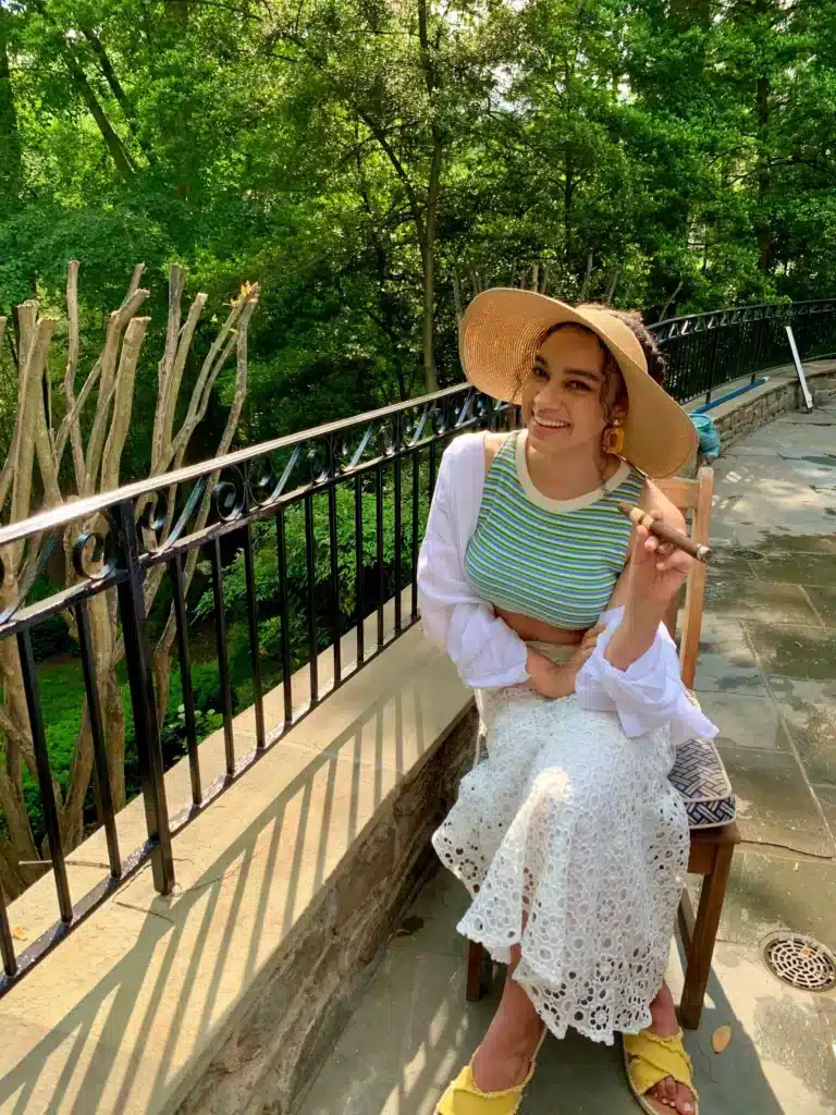 woman in elegant poolside outfit with sunhat, white maxi skirt, and crop top