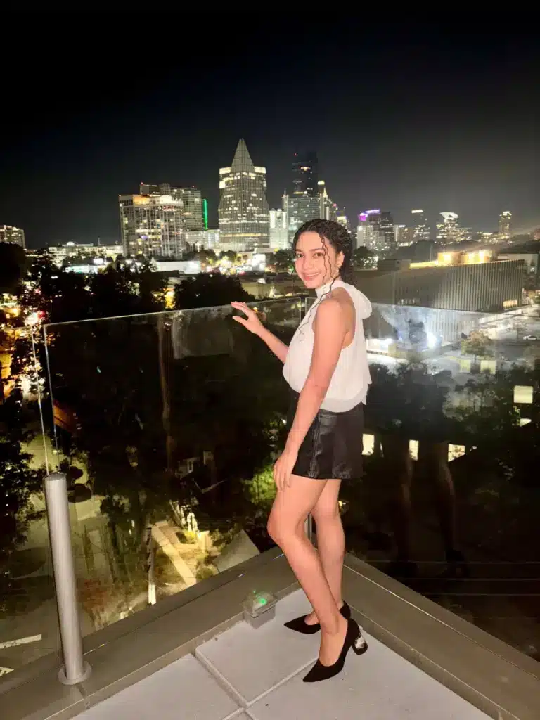 woman wearing elegant outfit with silk high neck sleeveless top, black leather shorts, and pointed heels
