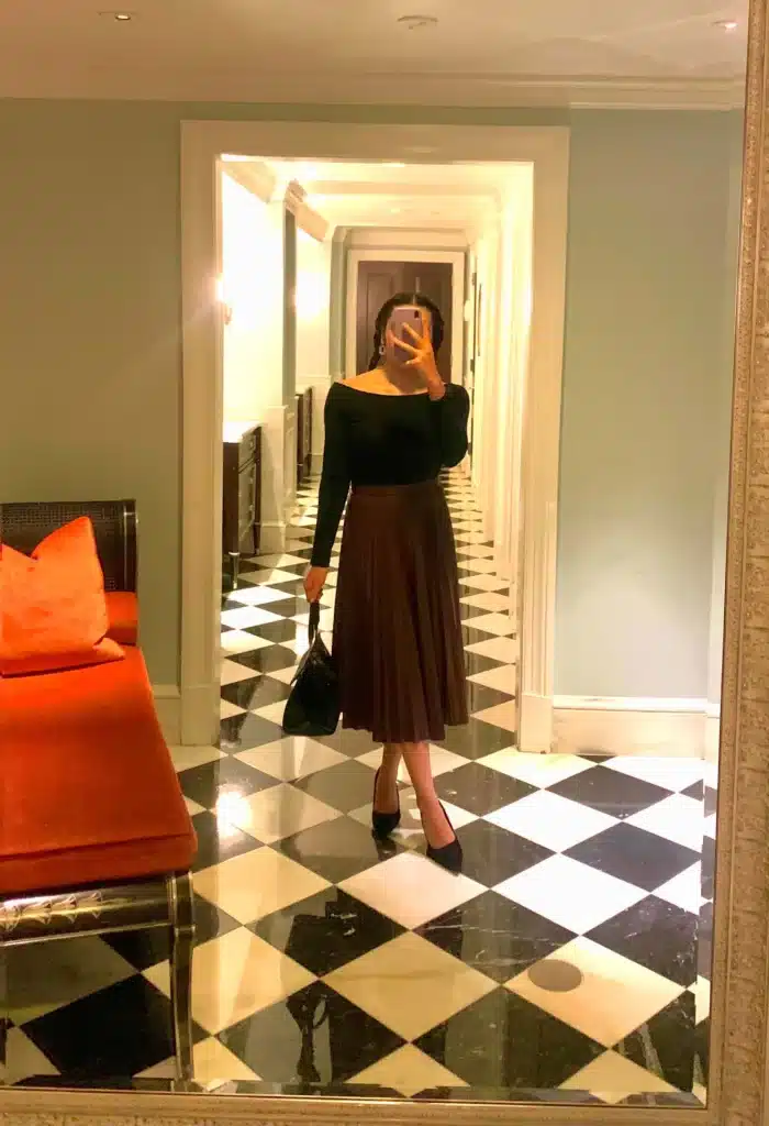 woman in pleated leather maxi skirt and boat neck top petite outfit idea