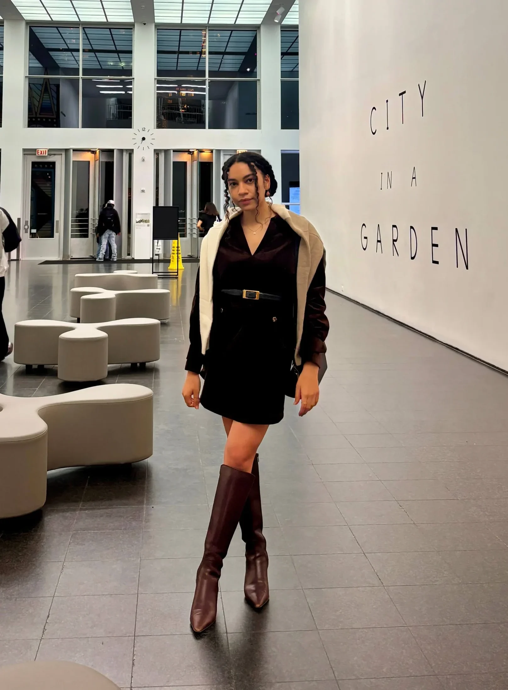 Woman in art gallery wearing elegant brown dress petite studio review